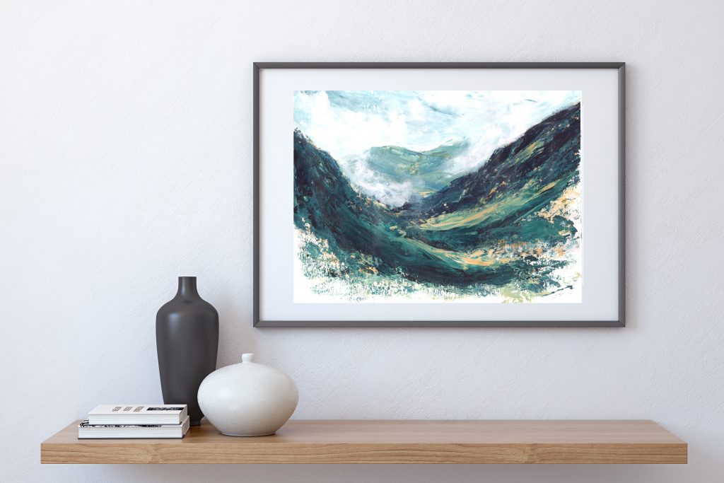 A framed painting of Green, blue and yellow impressionist landscape with sweeping lines of a the Scottish Highlands, Glen Coe Pass, hung on a grey wall above a light wood shelf with a black and a white vase and light coloured books upon it.