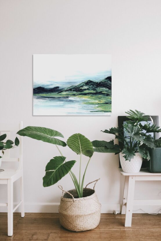 Abstract Mountain Landscape Painting with brlue and green marbled mountains against a white sky and white water, hung on a white wall above a green potted plant and white furniture