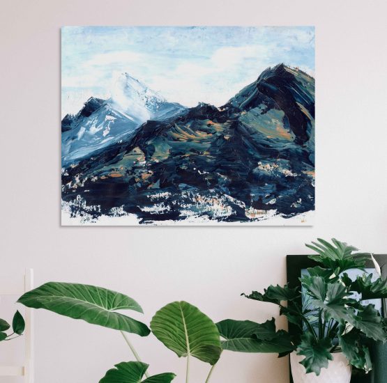 Blue, green and hints of orange and yellow marbled abstract mountain against a wispy white cloudy back ground with bits of blue sky peeking through original painting frameless, hung on a white wall above a white table with a green round leafed plant in a small white plant pot