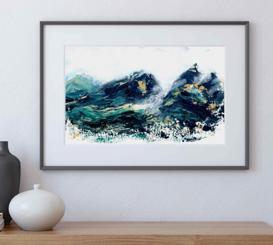 A framed Landscape painting witrh blue mountains capped with orange snowy peaks rests on a grey shelf against a grey wall next to a vase with sticks in it and paint brushes